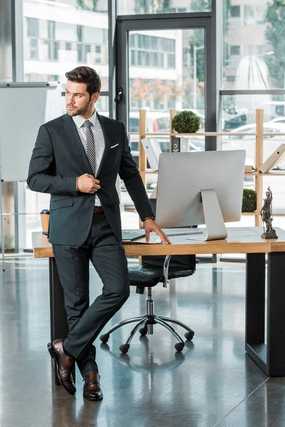 depositphotos 216437888 stock photo handsome businessman standing table office